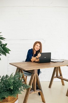 A person sitting at a table with a computer

Description automatically generated